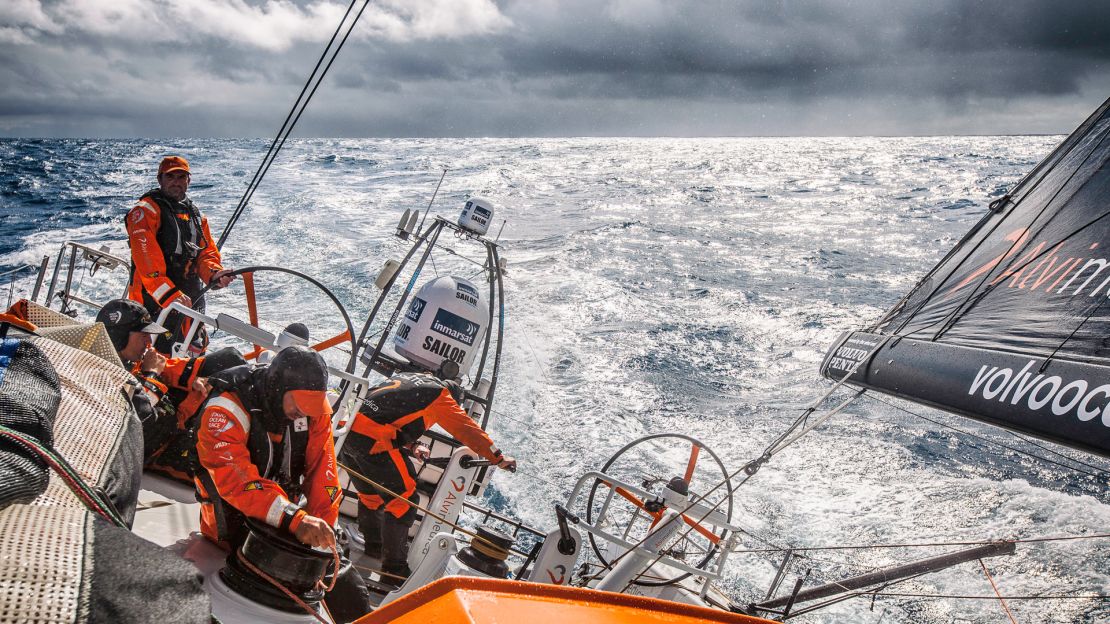 Charlie Enright on the helm as the clouds part for a momentary glimpse of sunlight with rain and squalls on the horizon in the 2015 race.