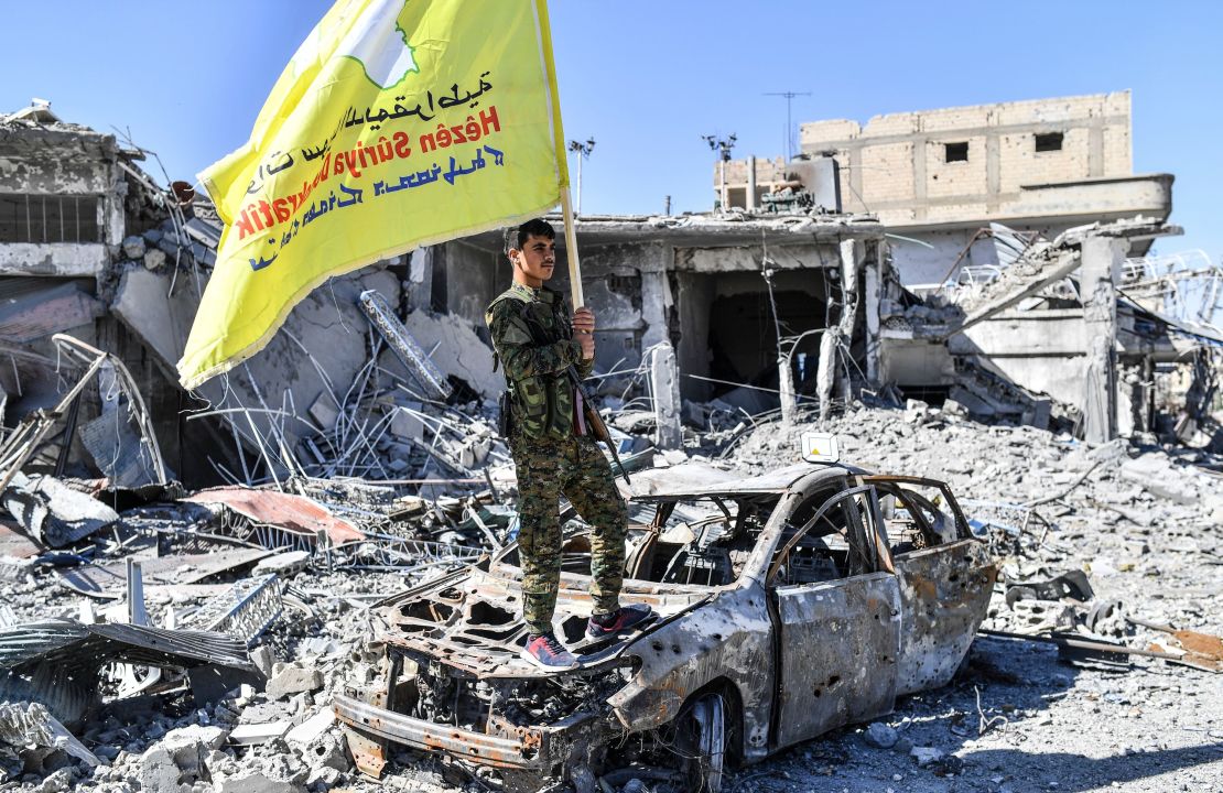 A member of the Syrian Democratic Forces (SDF), backed by US special forces, holds their flag at the Al-Naim square in Raqqa on October 17, 2017.