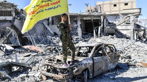 A member of the Syrian Democratic Forces (SDF), backed by US special forces, holds their flag at the Al-Naim square in Raqqa on October 17, 2017.