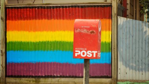 A Rainbow painted fence next to a post office box. Australians are not voting either Yes or No in the Same Sex Marriage Survey.
