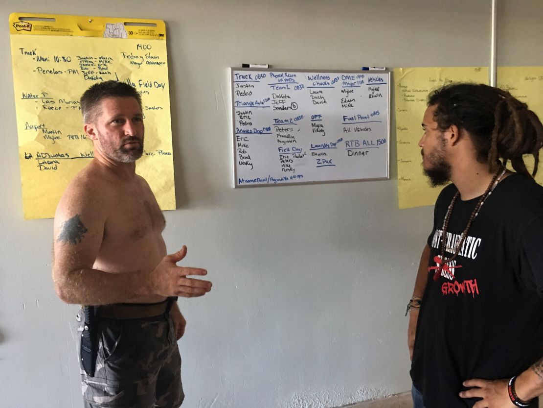 Veteran Eric Carlson, left, discusses volunteer aid operations with Nesky Hernandez at an abandoned airport in Mayaguez. 
