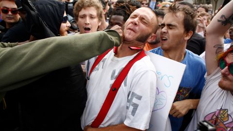 A man wearing a shirt with swastikas on it was punched by an unidentified person near the site of a planned speech by Richard Spencer.