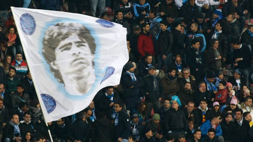 Fans of SSC Napoli wave a flag depicting former Napoli's Argentine forward Diego Armando Maradona during the Italian Serie A football match between SSC Napoli and AS Roma in San Paolo Stadium, in Naples, on March 09, 2014. AFP PHOTO/CARLO HERMANN        (Photo credit should read CARLO HERMANN/AFP/Getty Images)