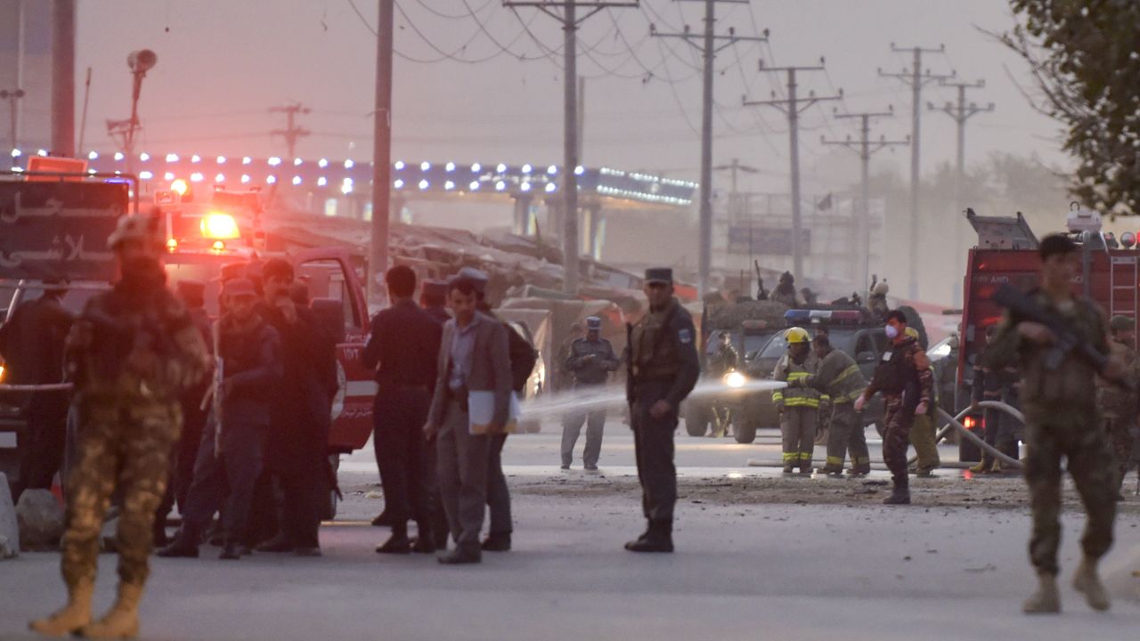 Afghan firefighters wash the road Saturday after a suicide bombing near a Kabul military academy.