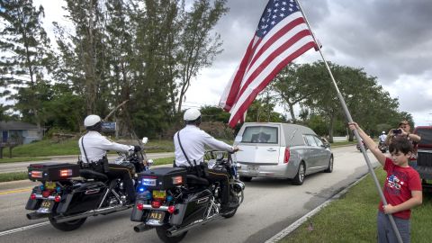 Residents watch as a hearse carrying Johnson's body makes its way to the burial site Saturday.