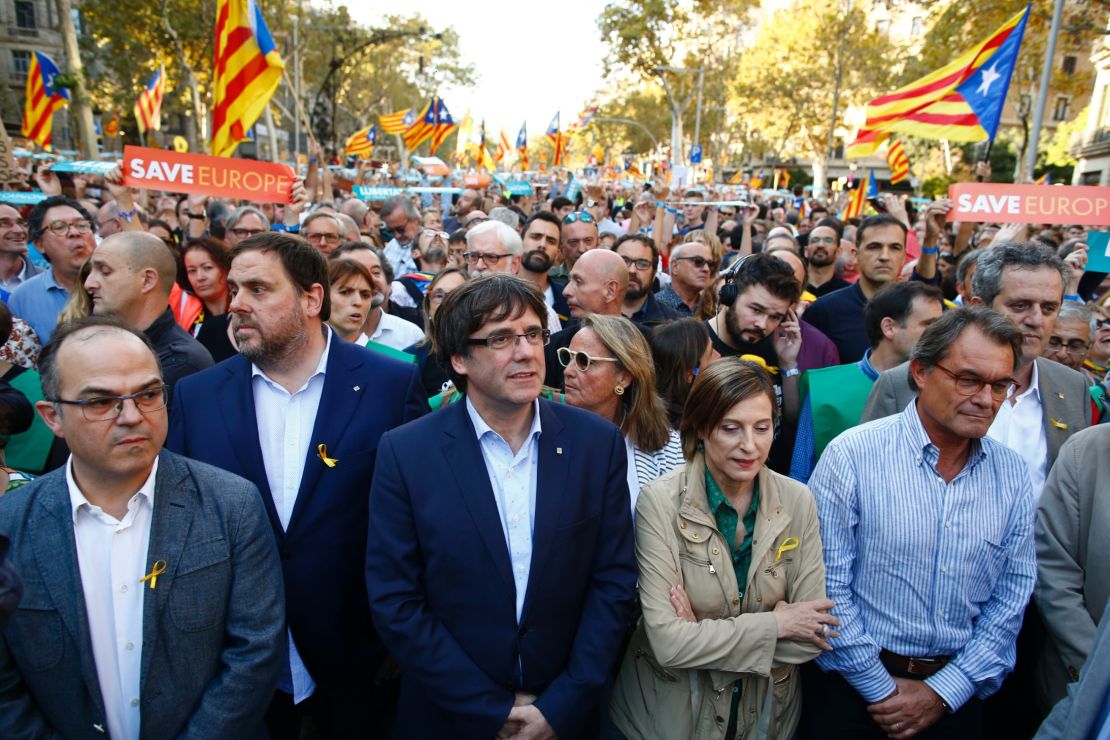 Catalan President Carles Puigdemont, center, takes part in an independence march in Barcelona on October 21.