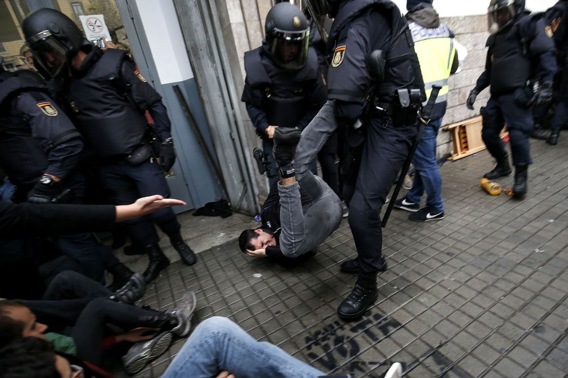 Spanish police officers try to disperse voters at a polling station in Barcelona on October 1.