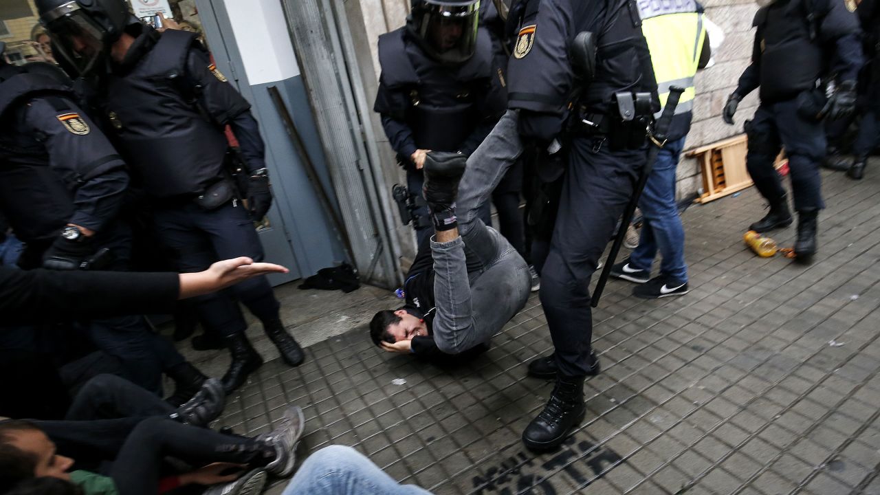 Spanish police officers try to disperse voters at a polling station in Barcelona on October 1.