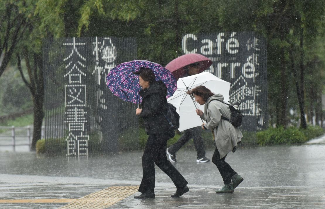 Pedestrians struggle with the wind and rain in Tokyo on October 22, 2017. 