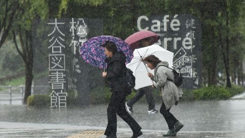 Pedestrians struggle with the wind and rain in Tokyo on October 22, 2017.