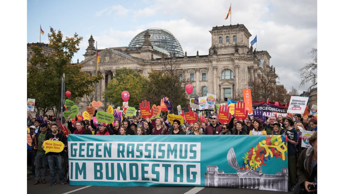 Thousands of people gathered near the German parliament Sunday to protest against the AfD. "Against racism in the parliament," reads the poster. 