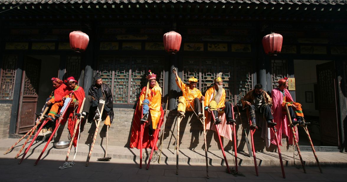 Stilt acrobats rest their (very long) legs after a street performance in Pingyao. 