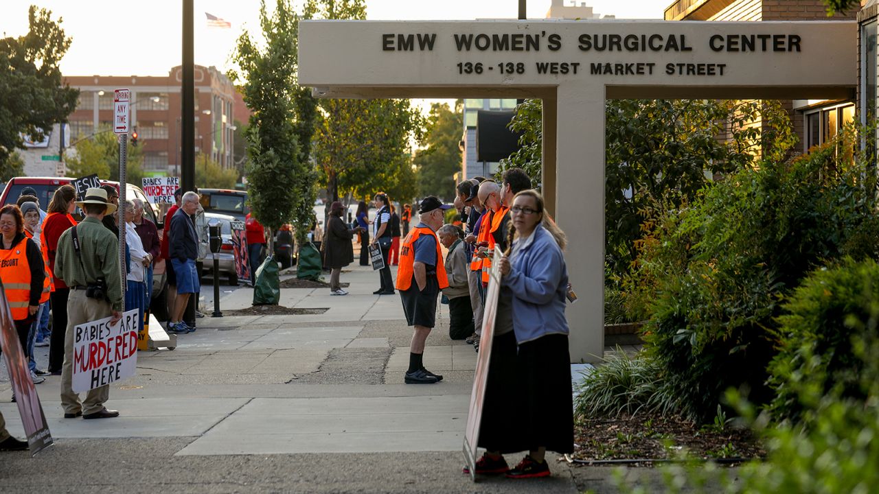 Anti-abortion demonstrators and volunteer clinic escorts are seen outside the EMW Women's Surgical Center in Louisville, Ky. on Aug. 26, 2017. The volunteer escorts wear vests to identify themselves.