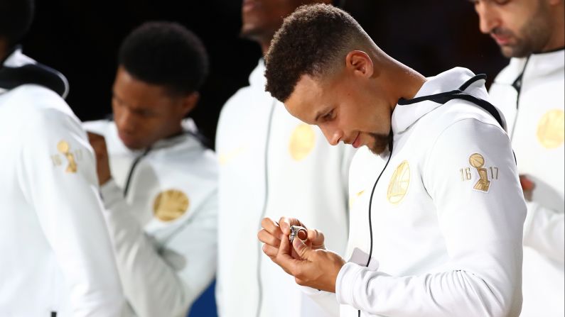 Stephen Curry admires the championship ring that he and other members of the Golden State Warriors received before a home game against Houston on Tuesday, October 17. <a href="index.php?page=&url=http%3A%2F%2Fwww.cnn.com%2F2017%2F04%2F05%2Fsport%2Fgallery%2Fnba-championship-rings%2Findex.html" target="_blank">Photos: The evolution of the NBA title ring</a>