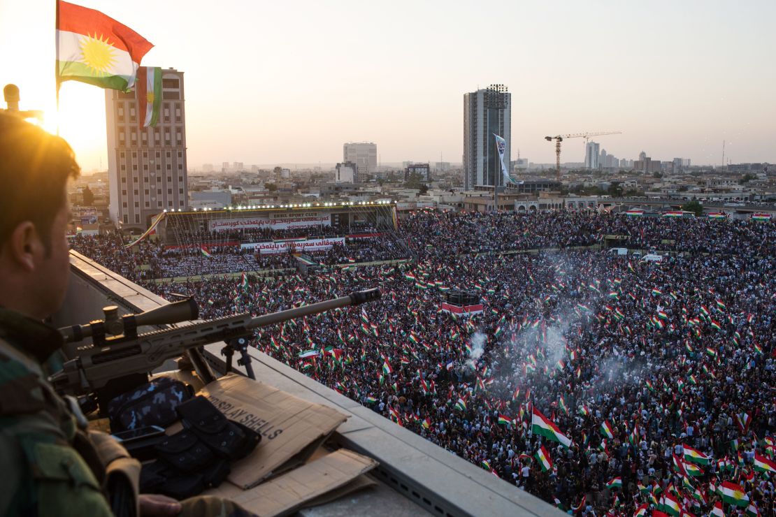 A Peshmerga fighter stands watch on a roof during a rally to urge people to vote in September's controversial independence referendum.