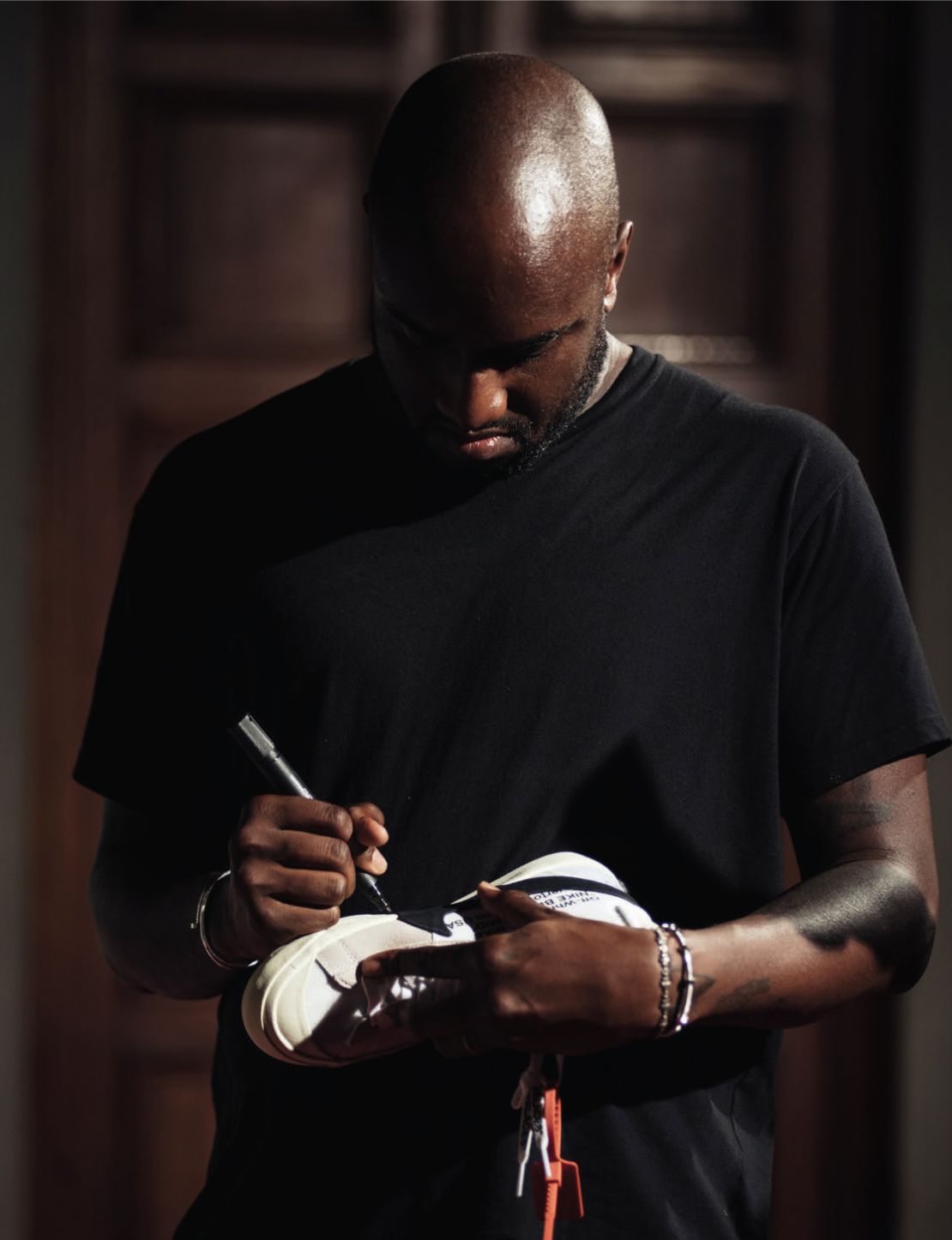 Virgil Abloh signs a shoe designed by his fashion brand, Off-White, in collaboration with Nike. 