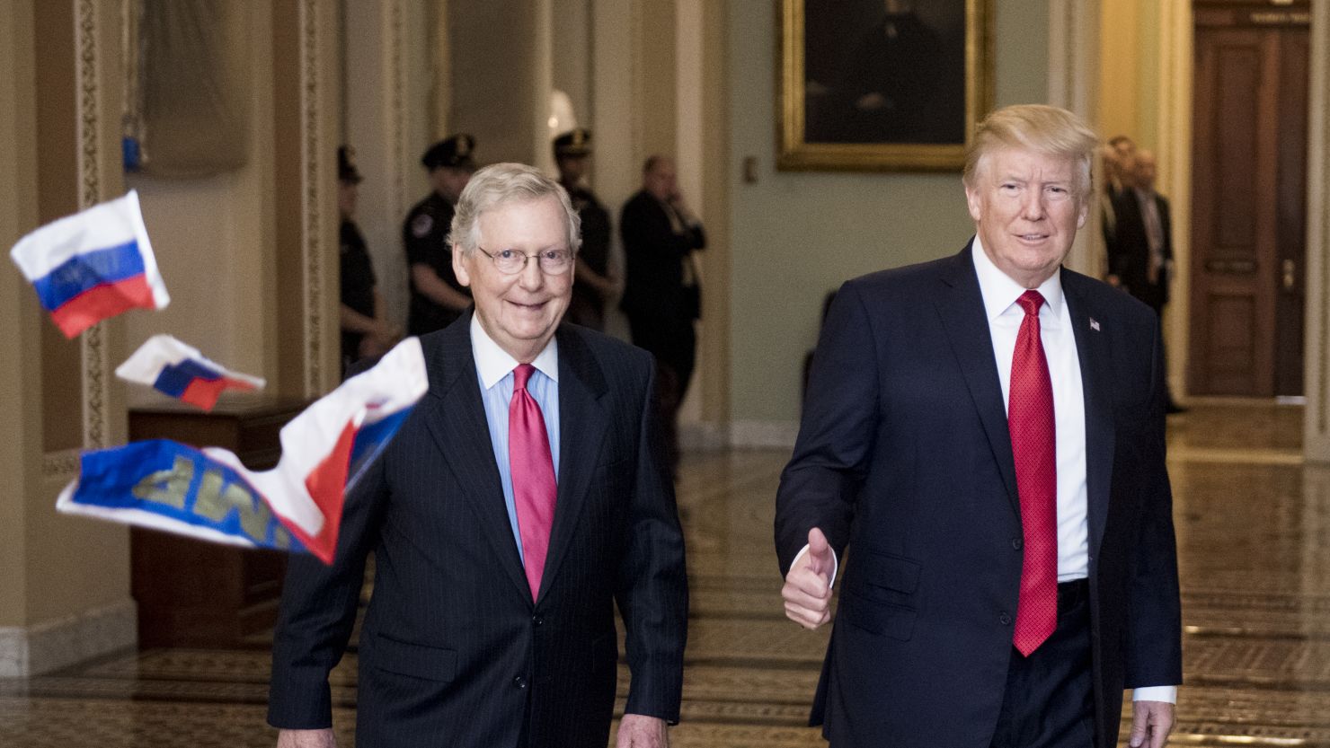 A protester throws Russian flags towards Senate Majority Leader Mitch McConnell and President Trump as they arrive for the Senate Republicans' policy lunch in the Capitol on Tuesday.