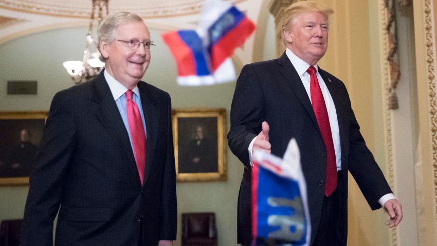 Small Russian flags bearing the word "Trump" are thrown by a protester toward President Donald Trump, as he walks with Senate Majority Leader Mitch McConnell, R-Ky., on Capitol Hill to have lunch with Senate Republicans and push for his tax reform agenda, in Washington, Tuesday, Oct. 24, 2017. (AP Photo/J. Scott Applewhite)