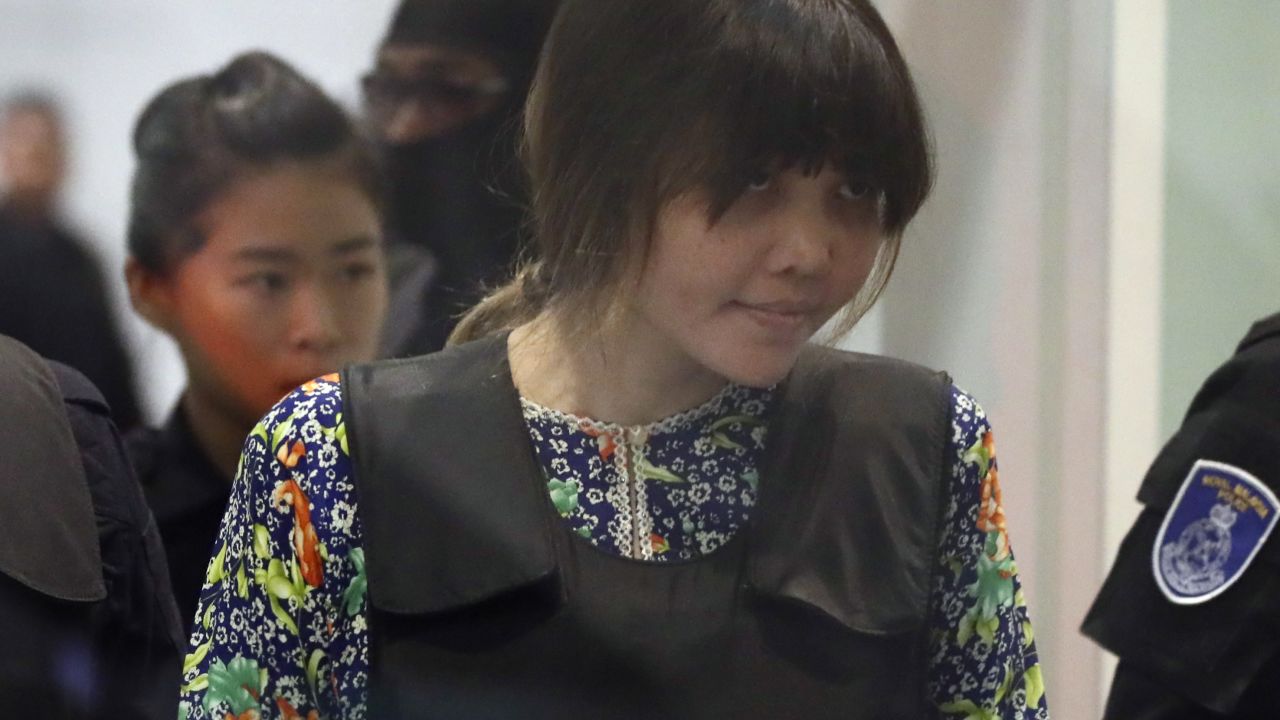 Huong is escorted by police as she arrives at the airport.
