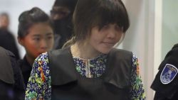 REMOVES REFERENCE TO RE-ENACTMENT - Vietnamese Doan Thi Huong is escorted by police as she arrives at Kuala Lumpur International Airport in Sepang, Malaysia, Tuesday, Oct. 24, 2017.  The two women accused of killing Kim Jong Nam, the North Korean leader's half brother, are touring at the Malaysian airport as participants in the murder trial visit the scene of the attack. (AP Photo/Sadiq Asyraf)