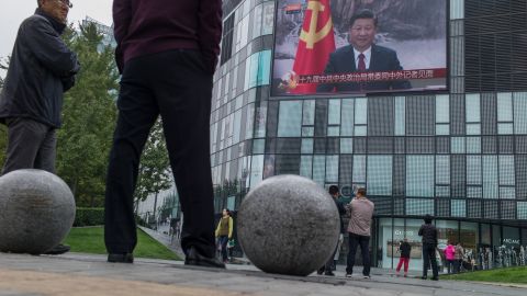 Residents watch a large screen showing Chinese President Xi Jinping revealing the new Politburo Standing Committee, the nation's top decision-making body at the Great Hall of the People in Beijing on October 25, 2017.