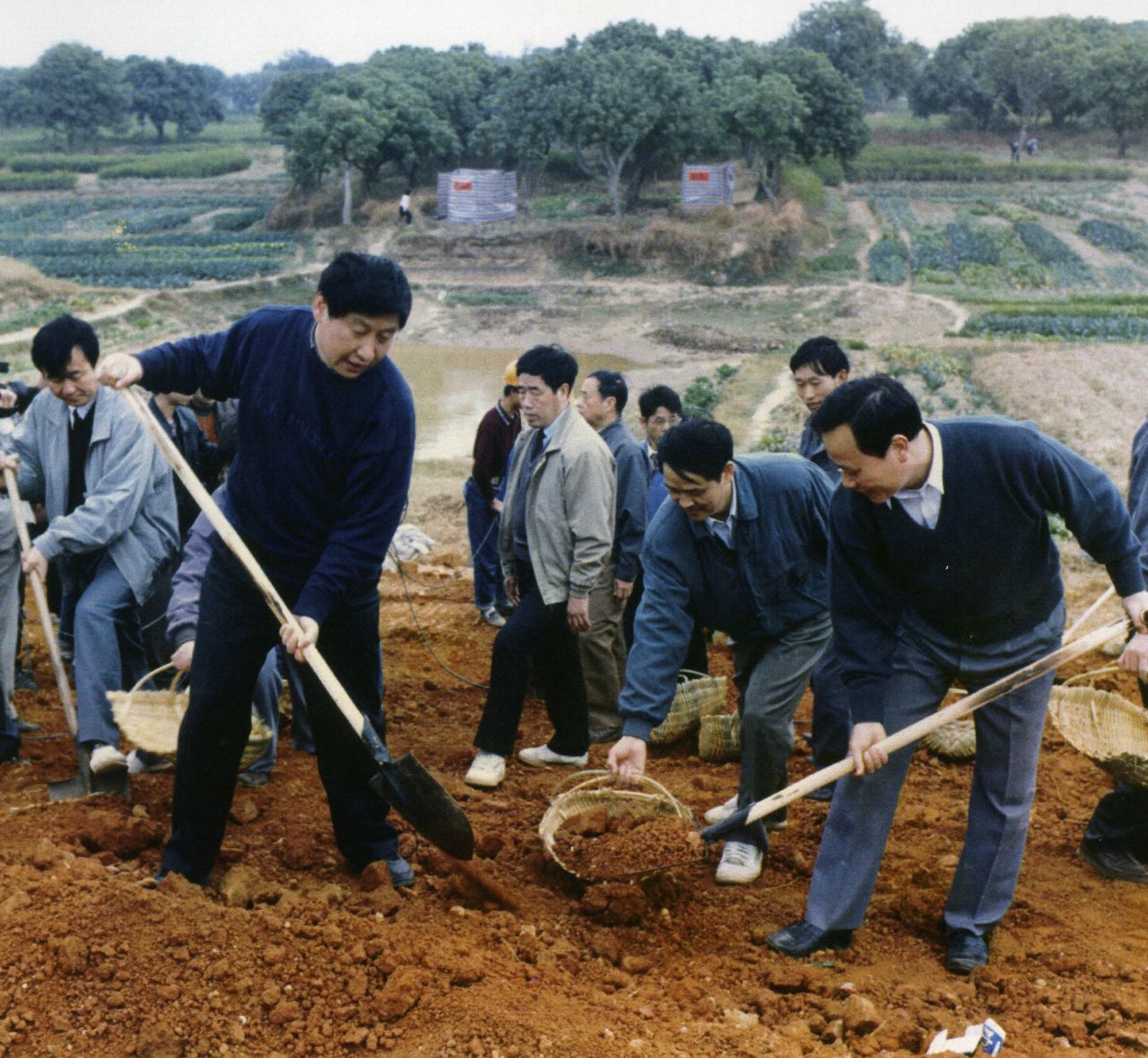 Xi, front left, helps reinforce a levee of the Minjiang River in 1995.