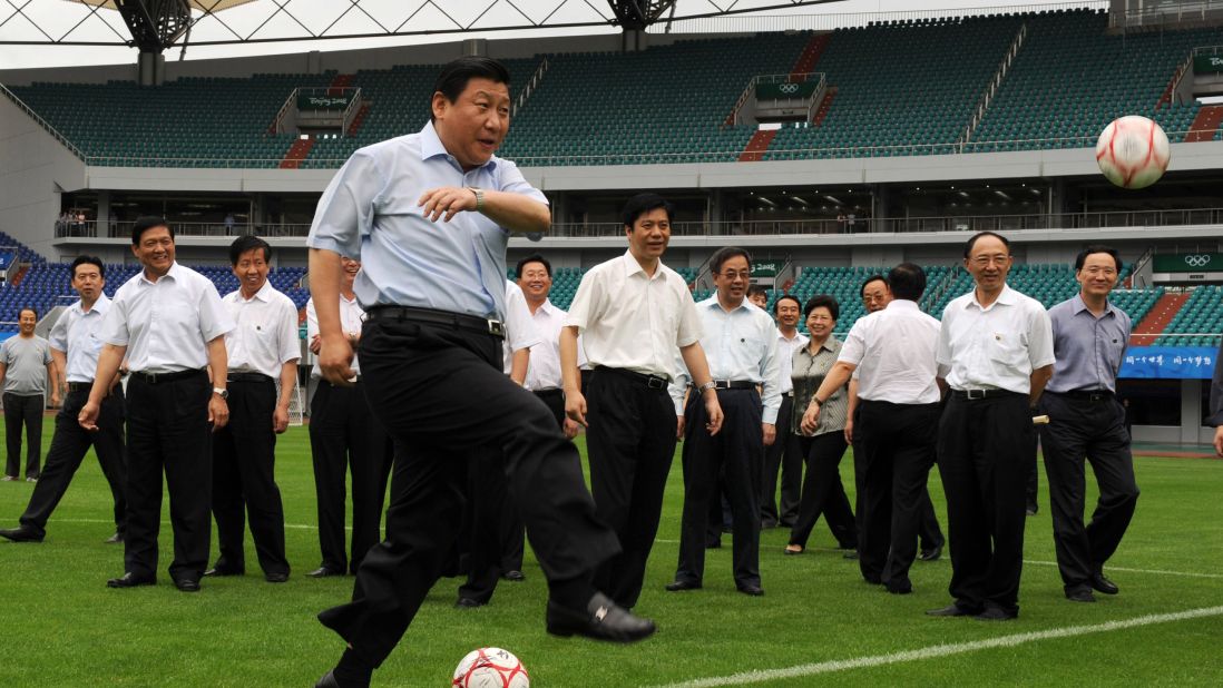 Xi kicks a soccer ball in 2008 as he inspects a field in Qinhuangdao, China. The stadium was hosting games during the 2008 Summer Olympics.