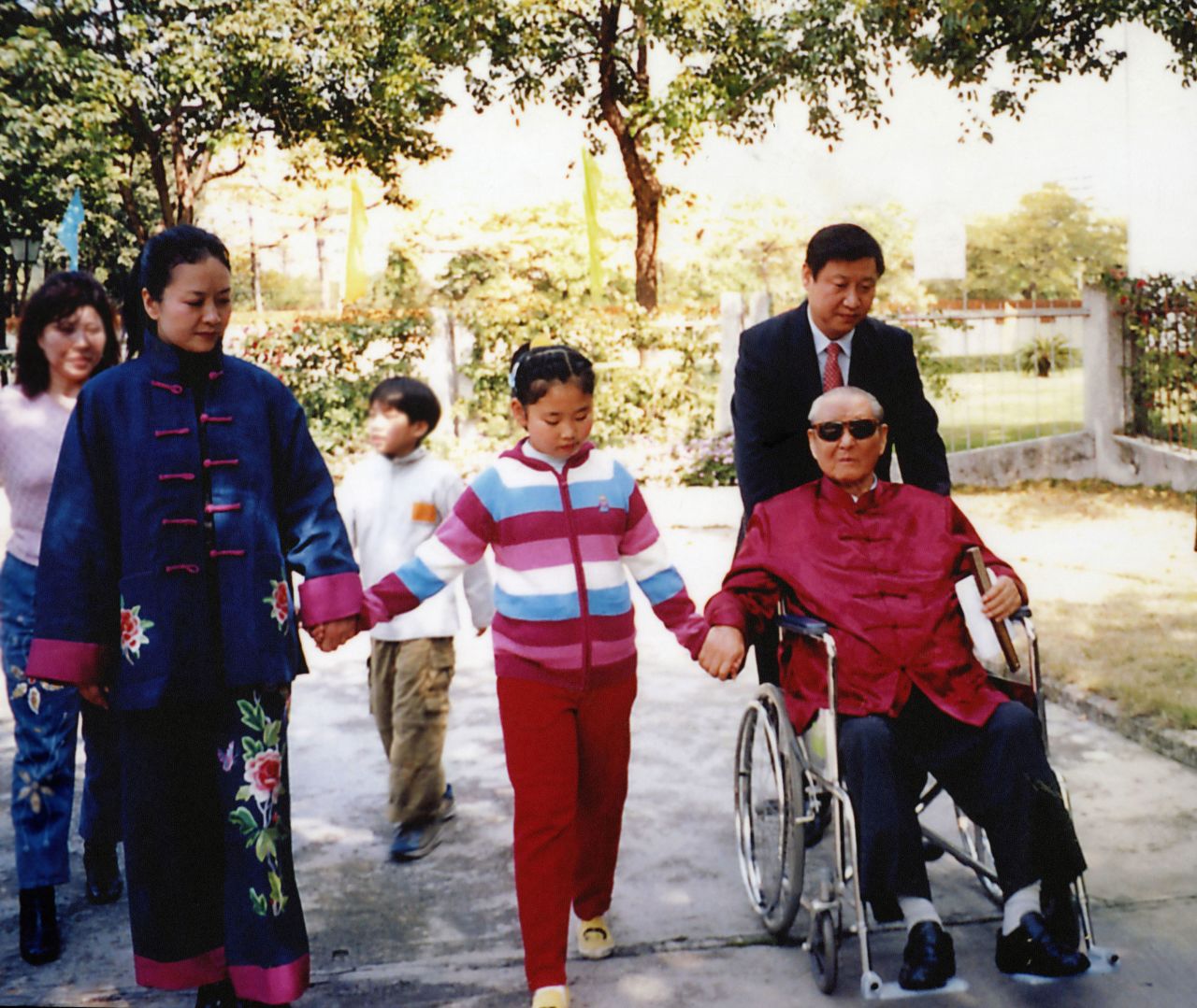 Xi pushes his father as he walks with his wife and his daughter, Xi Mingze, in 2012.