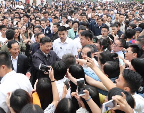 Xi shakes hands with teachers and students while visiting a university in Beijing in May 2017.