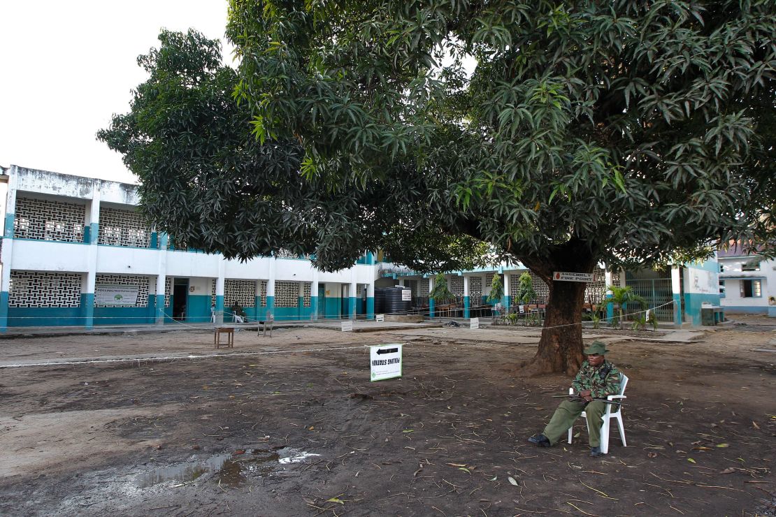 A Kenyan policeman sits outside an empty polling station in Mombasa on Thursday.