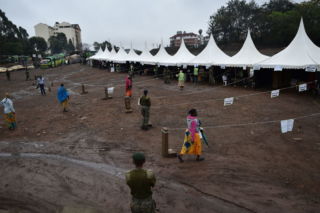 A police official looks on as residents walk into a polling station the Kibera slum area of Nairobi. 