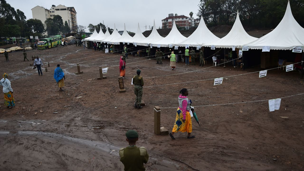 A police official looks on as residents walk into a polling station the Kibera slum area of Nairobi.