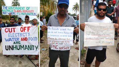 Manus Island refugees hold signs during a daily protest calling for the Australian government to find another solution.