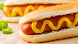 Traditional yummy hot dogs with mustard, close-up. Hot pepper, baking paper. Fast food and obesity.; Shutterstock ID 617277662; PO: Health