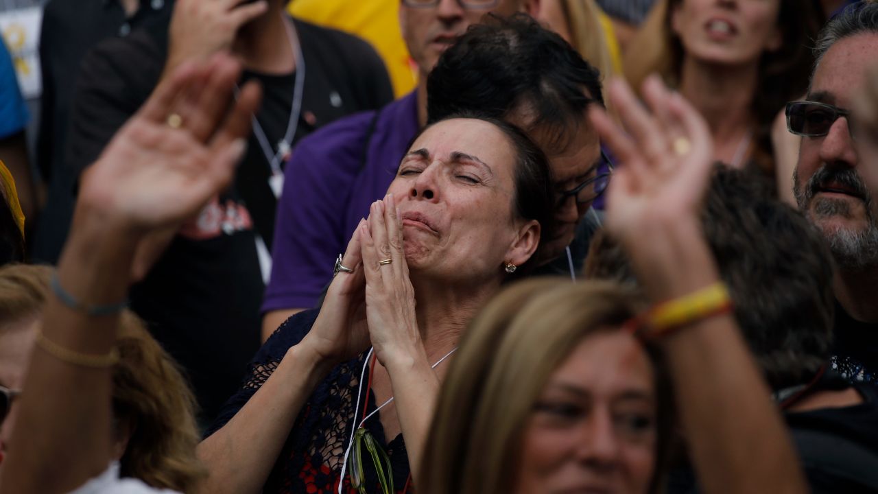 A protester appears to pray as she takes part in a rally outside the Catalan Parliament.