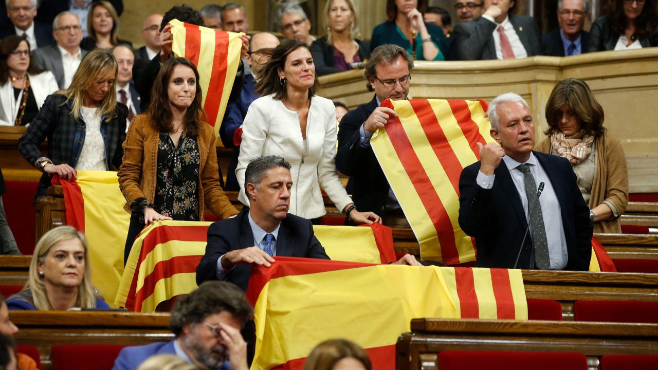 Opposition Catalan lawmakers place Spanish national flags and Catalan esteladas over the benches ahead of a vote on independence inside the Catalan Parliament in Barcelona, Spain. 