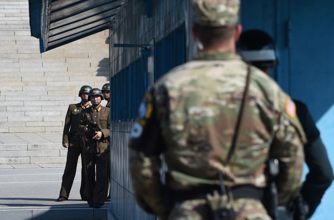 North Korean soldiers (L) look at the South side while US Secretary of Defence Jim Mattis and South Korean Defence Minister Song Young-Moo visit at the truce village of Panmunjom in the Demilitarized Zone (DMZ) on the border between North and South Korea on October 27, 2017. 
