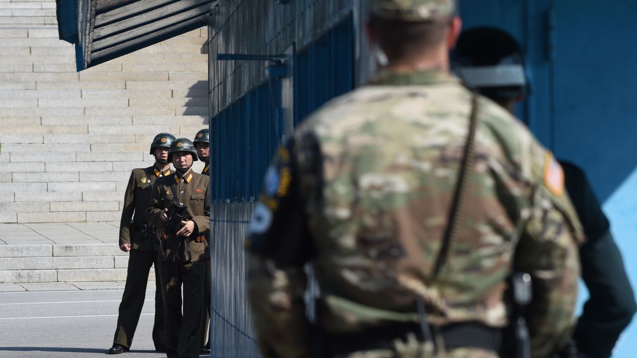 North Korean soldiers (L) look at the South side while US Secretary of Defence Jim Mattis and South Korean Defence Minister Song Young-Moo visit at the truce village of Panmunjom in the Demilitarized Zone (DMZ) on the border between North and South Korea on October 27, 2017.