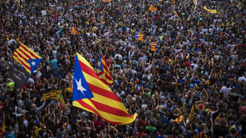 People wave "estelada," or pro-independence flags, outside the Palau de la Generalitat in Barcelona, Spain, on Friday, October 27, after Catalonia's regional Parliament <a >passed a motion</a> it says establishes an independent Catalan Republic. 