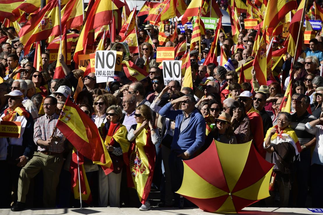People hold signs reading "No to the coup" while waving Spanish flags during a demonstration urging unity in Madrid on Saturday.