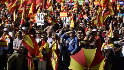 People hold signs reading "No to the coup" while waving Spanish flags during a demonstration urging unity in Madrid on Saturday.
