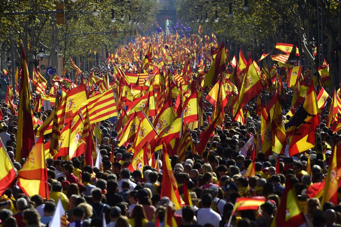 Protesters wave Spanish and Catalan flags during a pro-unity rally in Barcelona on October 29, 2017.