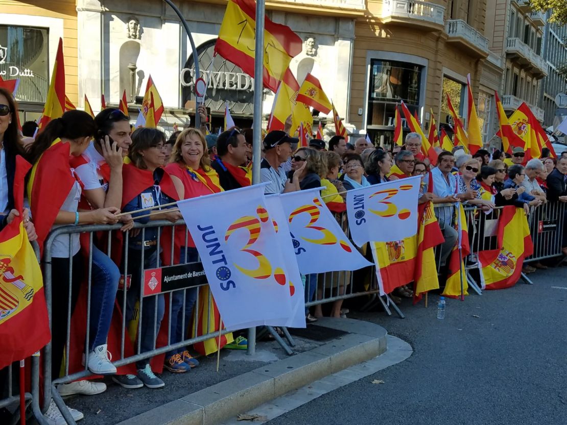 Anti-independence protesters in Barcelona on Sunday holding Spanish flags, as well as others that say "together."