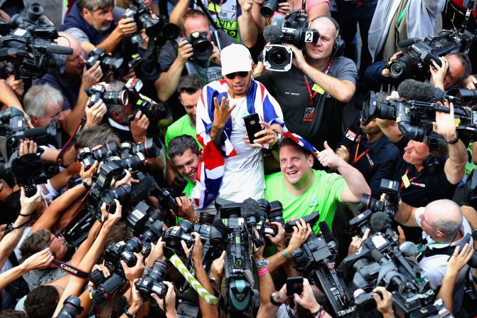 Hamilton poses for the cameras signaling his four world titles. How many more titles can the Briton win?