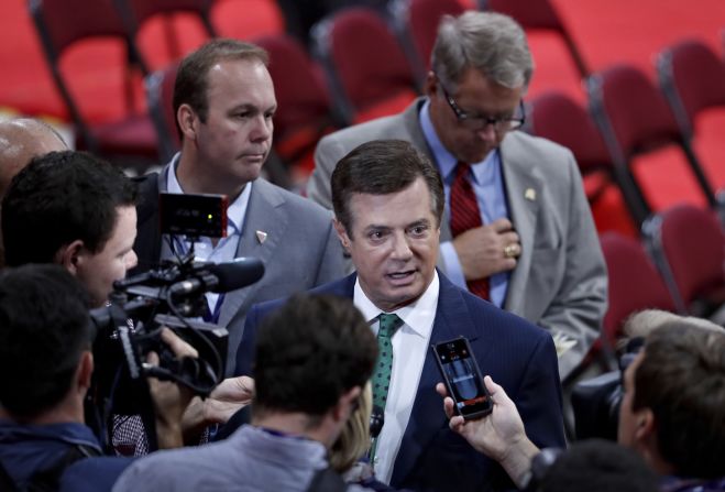 Manafort is surrounded by reporters on the floor of the Republican convention in Cleveland on July 17, 2016. Gates, a former business associate of Manafort and former Trump campaign aide, stands to his right.<br />