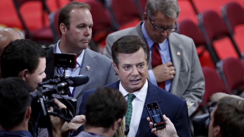 FILE - In this July 17, 2016 file photo, President Donald Trump's Campaign Chairman Paul Manafort is surrounded by reporters on the floor of the Republican National Convention in Cleveland. Rick Gates, a former business associate to Manafort and former campaign aide to Republican presidential candidate Donald Trump, is left center.   (AP Photo/J. Scott Applewhite)