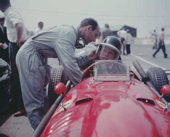 British racing driver Stirling Moss (left) adjusts Hawthorn's helmet before a race. The documentary contains many gruesome moments, but also many previously unseen clips of drivers off the track -- in the pit lane, horsing about and on the road as they made their way from one race to the next. <br />