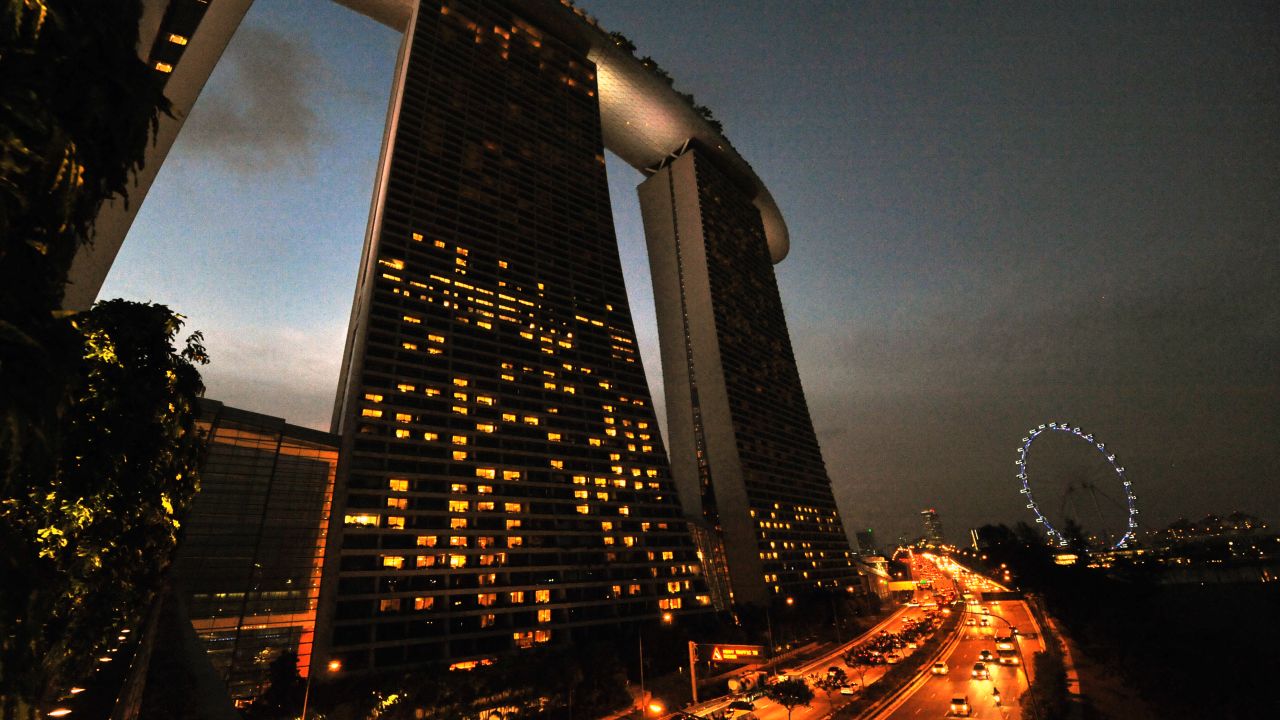 A general view shows cars driving on a motorway in front of the Marina Bay Sands hotel buildings in Singapore on June 28, 2012. 