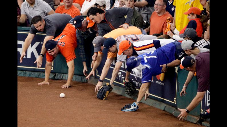 Fans reach for a foul ball in Houston during Game 5 of the World Series on Sunday, October 29.