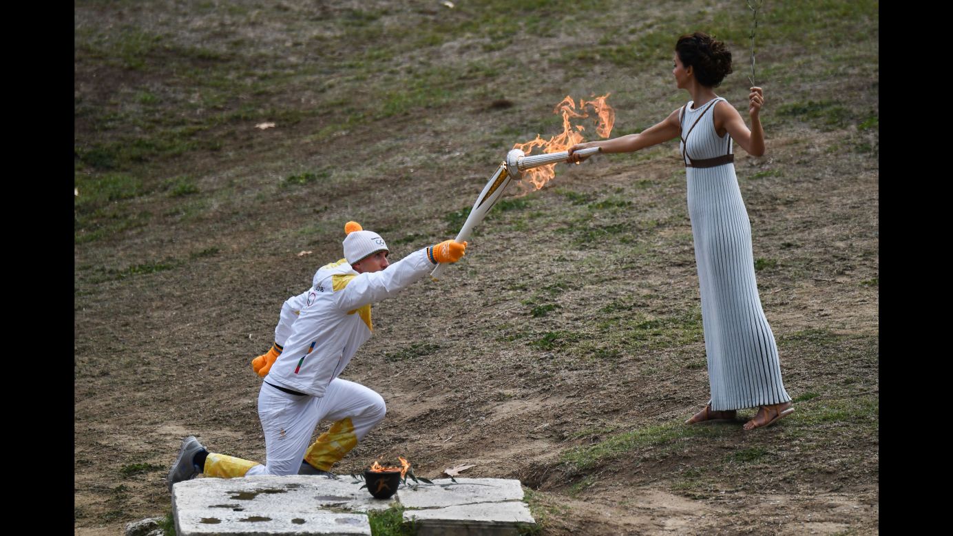 The Olympic torch begins its trip from Greece to PyeongChang, South Korea, as cross-country skier Apostolos Angelis takes the flame from actress Katerina Lechou on Tuesday, October 24.